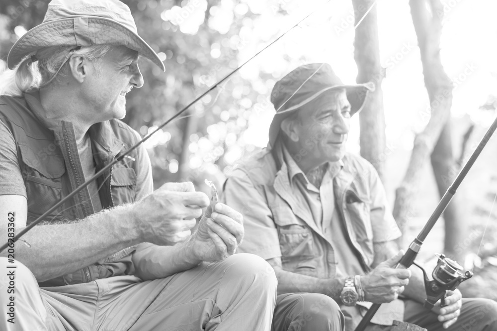 Senior friends fishing by the lake