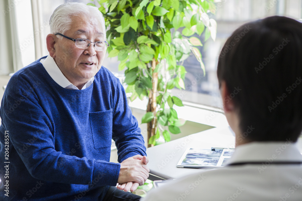 若い医者の診断を受ける老人