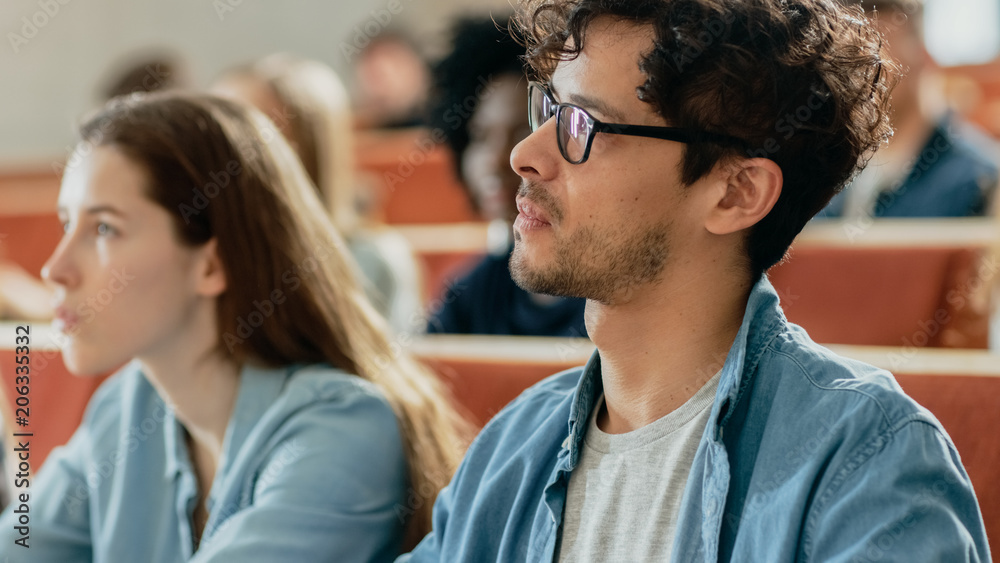 专注的西班牙裔学生在课堂上听讲座。年轻人在大学学习