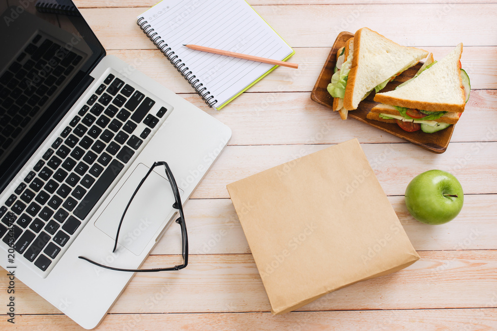 Lunch bag with sandwich and fruits in office table