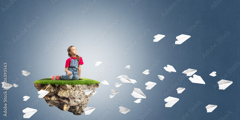 Concept of careless happy childhood with girl and paper planes flying around