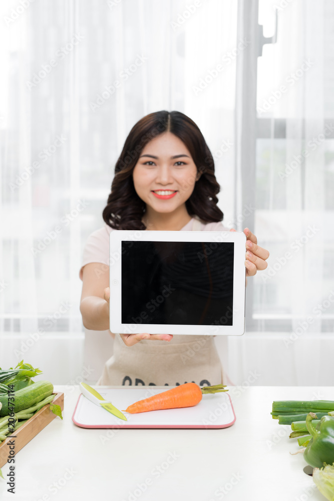 Picture of young asian woman with tablet in kitchen