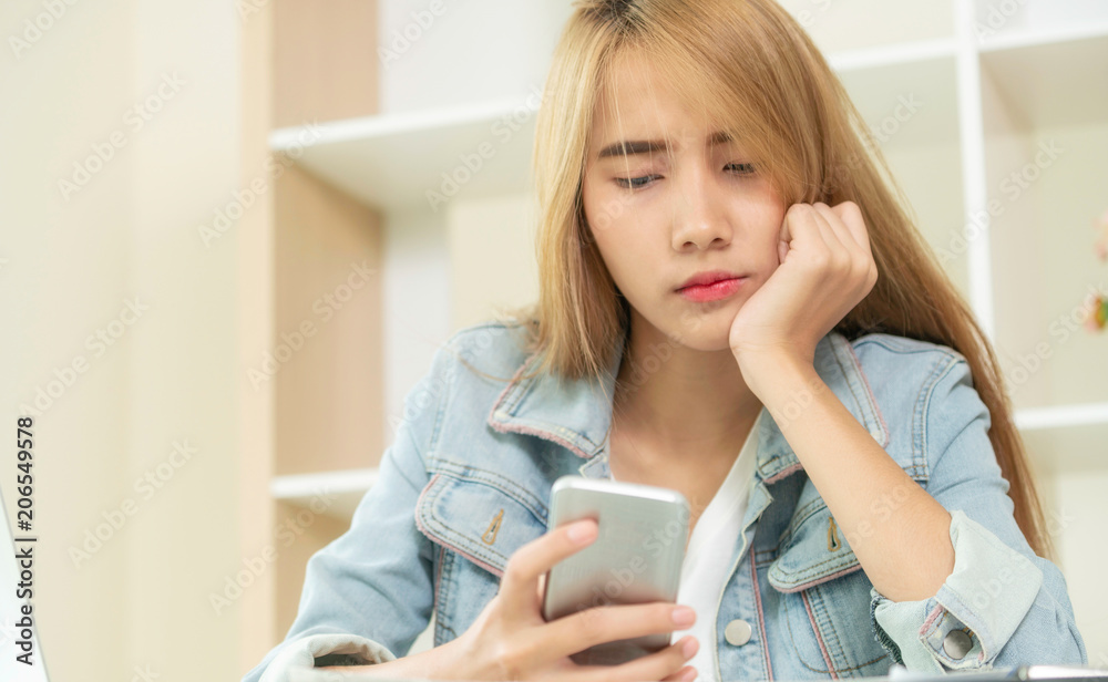 Unhappy businesswoman looks at smart phone.