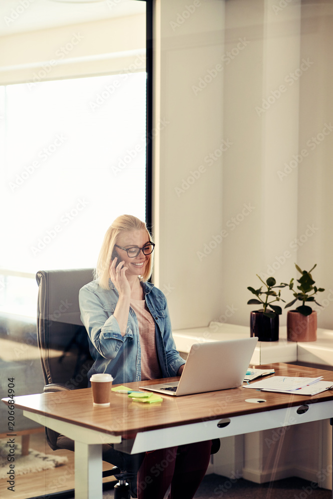 年轻的女商人在办公室里打手机