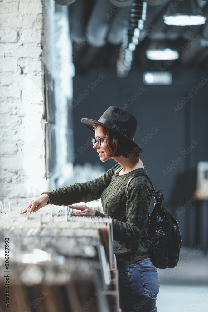 年轻女孩在商店浏览唱片