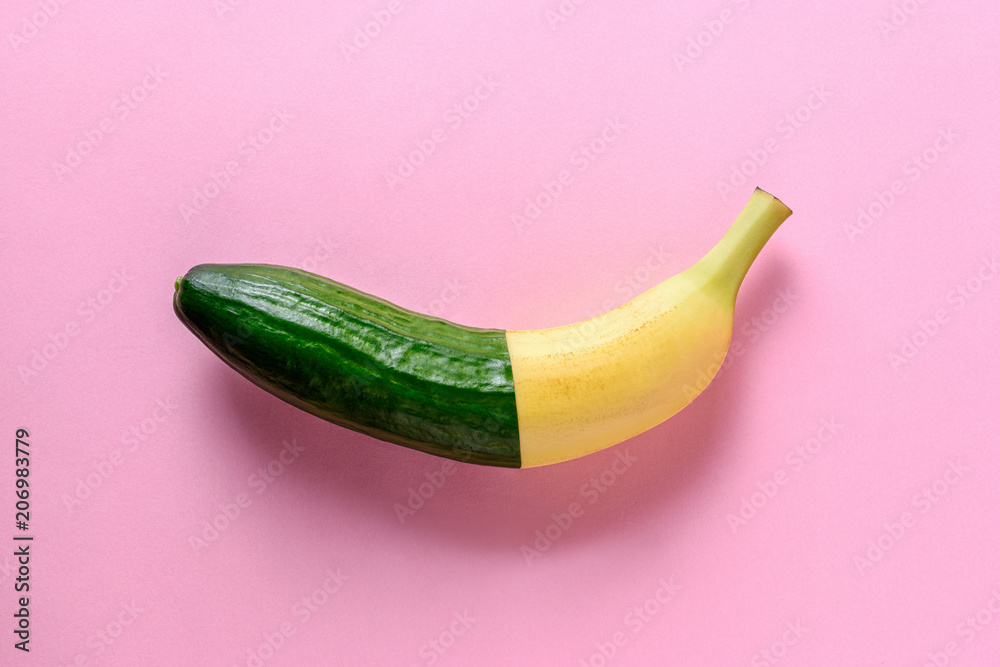 Сonnected banana and cucumber on pink background. Minimal fruit concept.