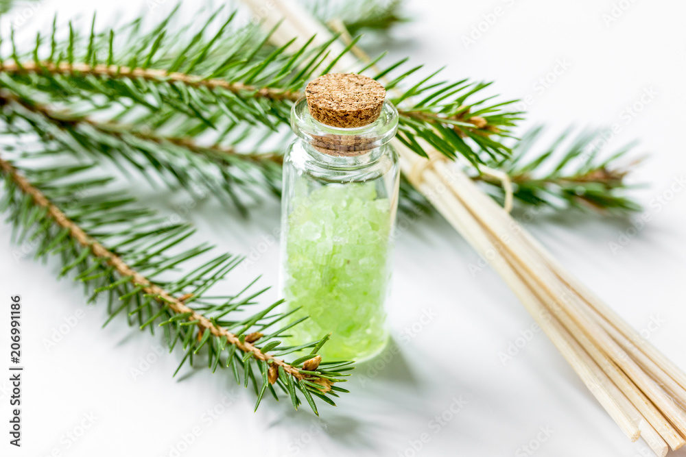 Bottles of sea salt and fir branches for aromatherapy and spa on