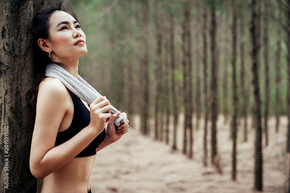 亚洲女孩周末在一片郁郁葱葱的松林里锻炼。运动女孩和李娜