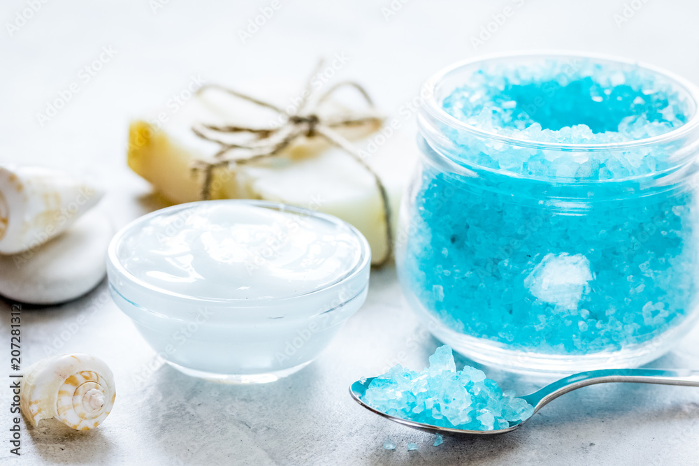 set for bath with blue salt and shells on stone table background