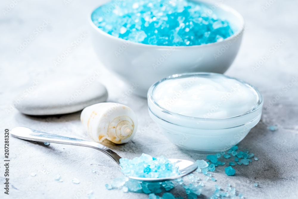 blue set for bath with salt and shells on stone table background