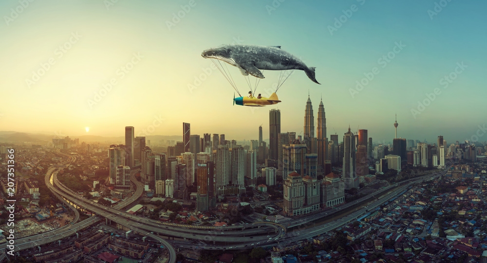 Whale floats in the sky and carrying a plane with two young little sister . Travel concept.