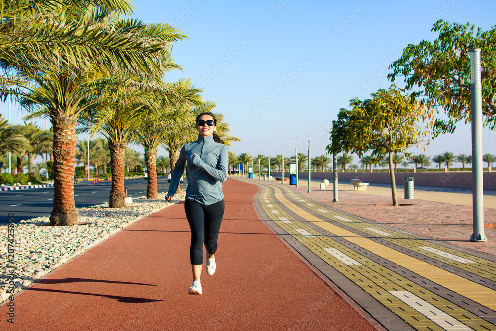 海边跑步跑道上慢跑的女孩