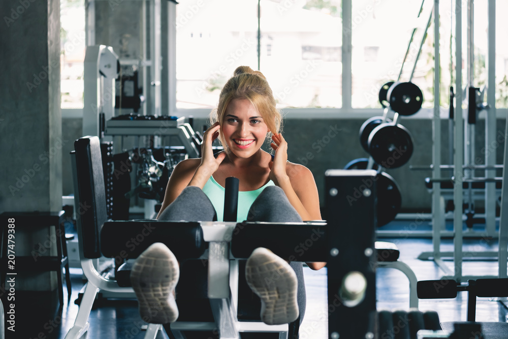 Woman doing sit up and weight training at sport gym with happy and smile, gym workout concept