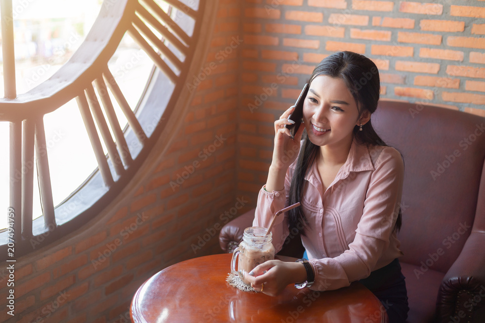 亚洲女子在咖啡馆使用电话复古色