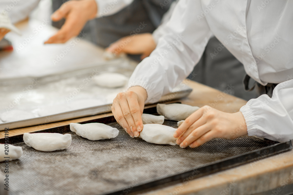 工人在制造过程中用馅料制作生面包