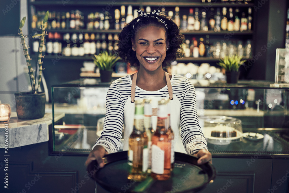 Friendly African restaurant server holding a tray of drinks