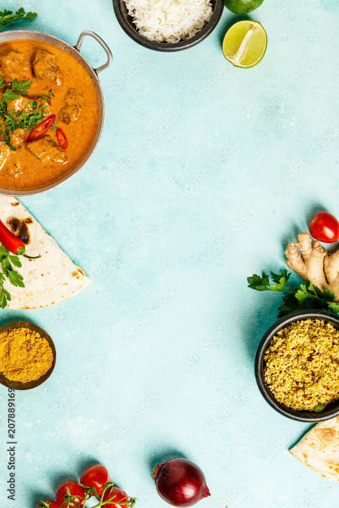 Traditional curry and ingredients on blue background