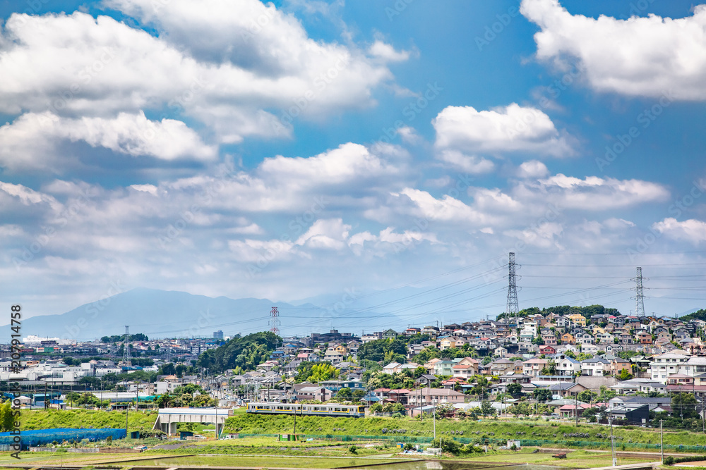 郊外の住宅街を走るローカル線