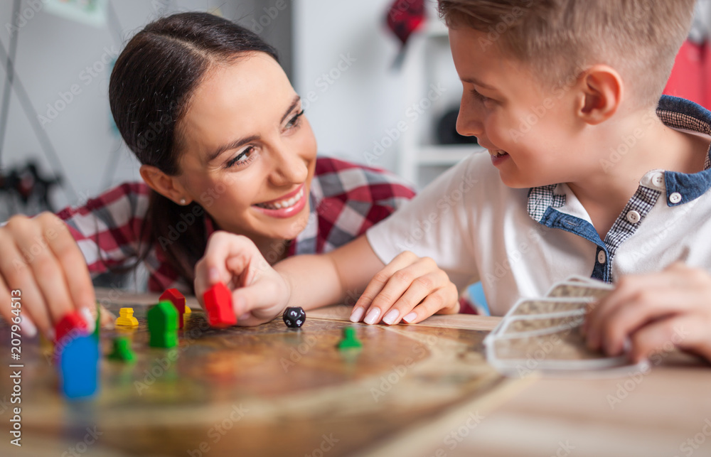 母子俩在家青少年房间玩现代棋盘游戏