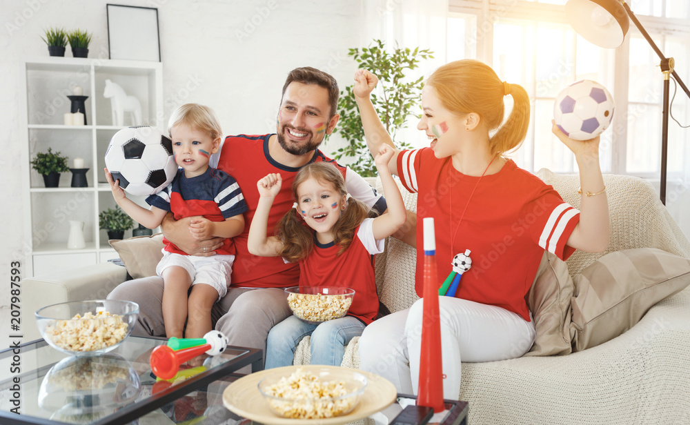 family of fans watching a football match on TV at home