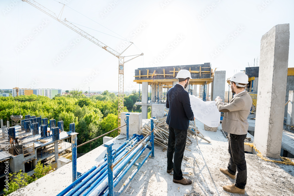 两名工程师或建筑师在施工期间一起绘制房屋图纸