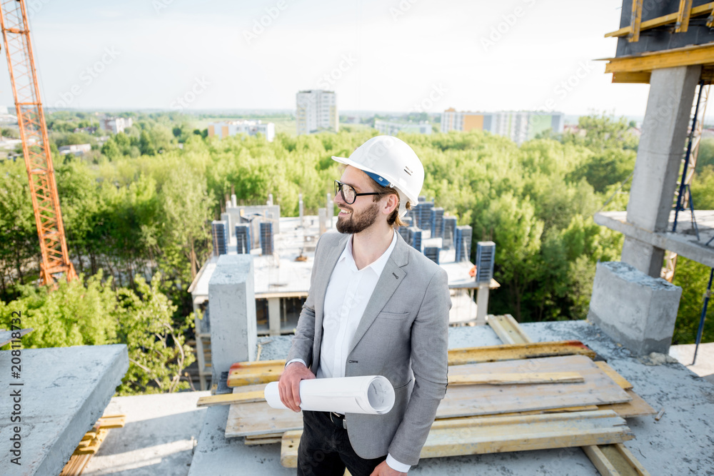 站在室外结构上的图纸监督房屋施工过程的人