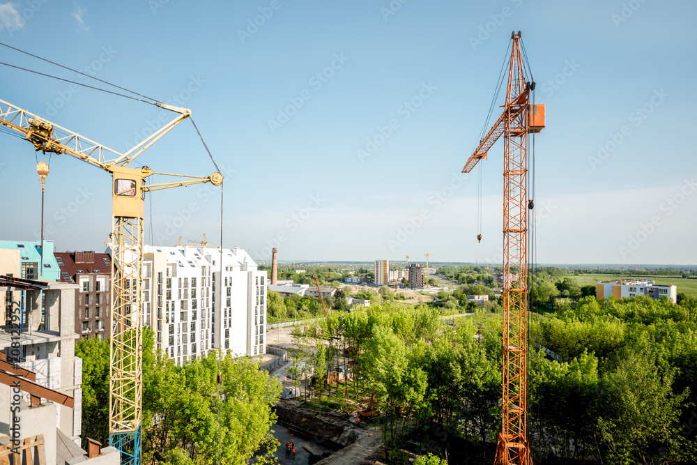 日落时建筑起重机在施工现场的景观