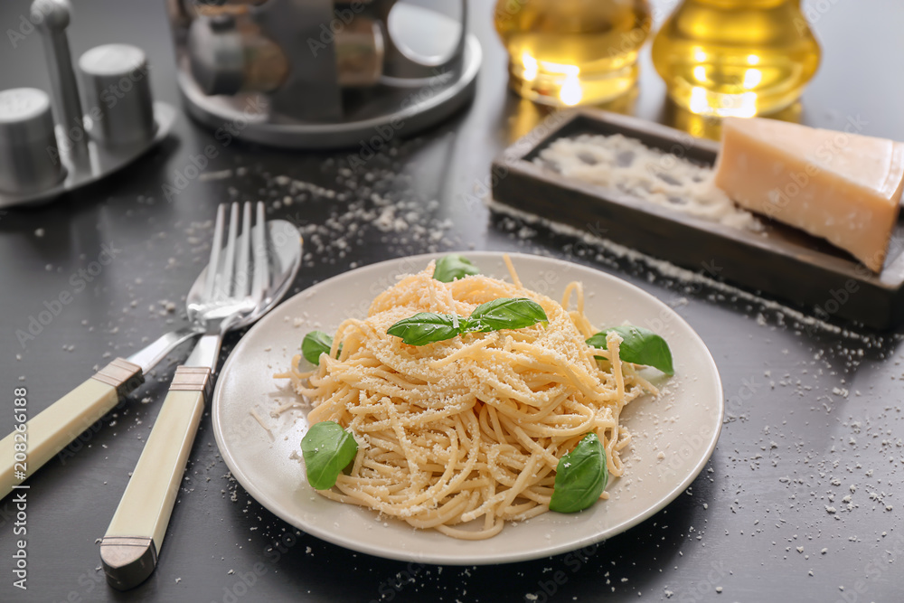 Plate with spaghetti and basil on table. Delicious pasta recipes