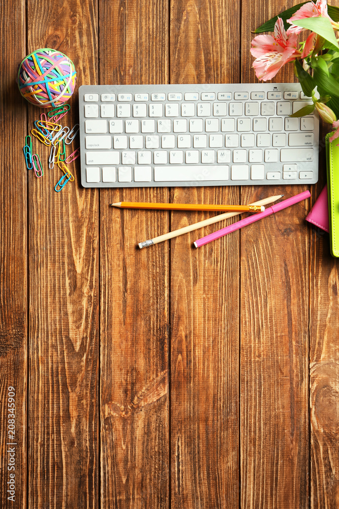 Computer keyboard, flowers and stationery on table, flat lay. Workplace composition