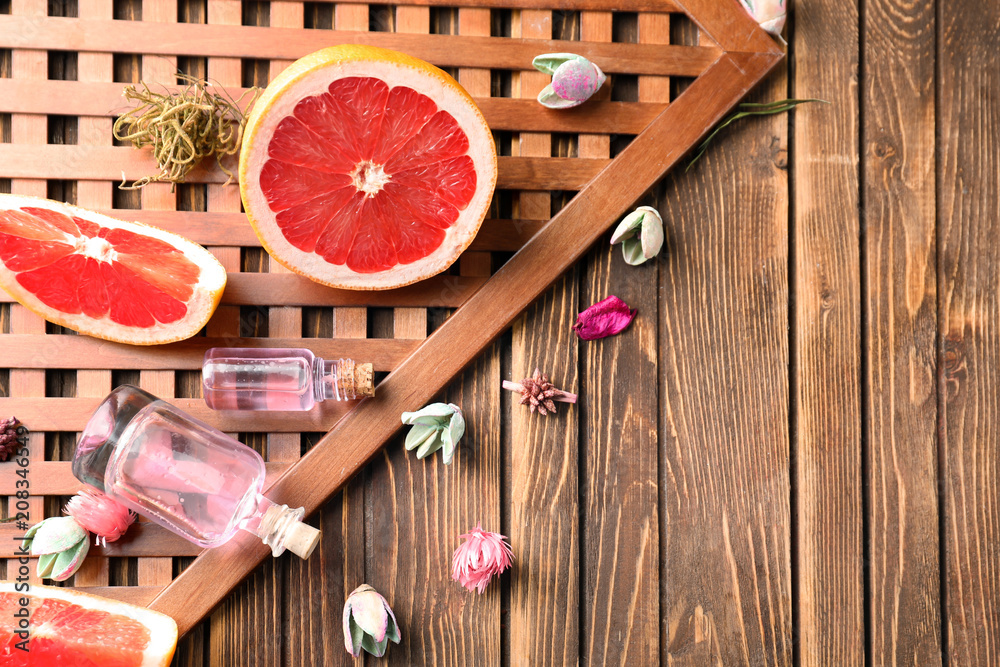 Composition with bottles of citrus essential oil on wooden background