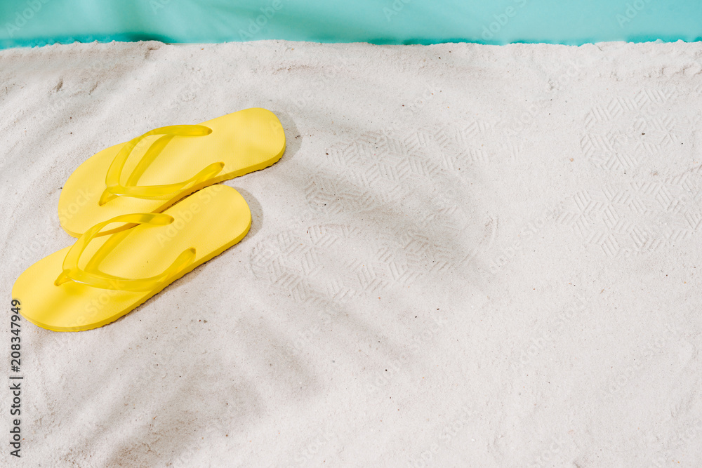 A Summer vacation background with a pair of sandals on beach