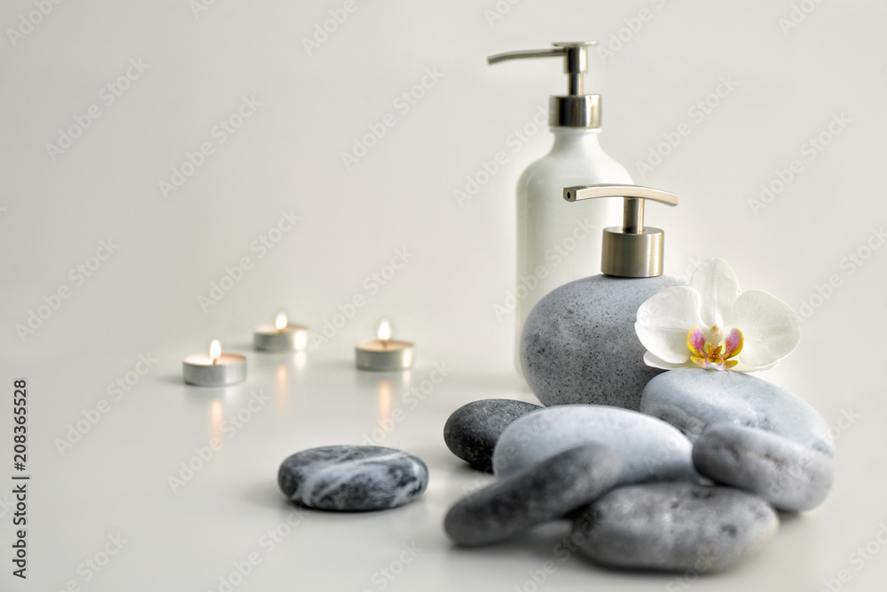 Spa composition with stones and cosmetics on light background