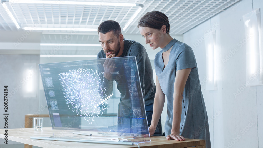 In the Near Future Male and Female Computer Engineers Talk While Working on the Transparent Display 