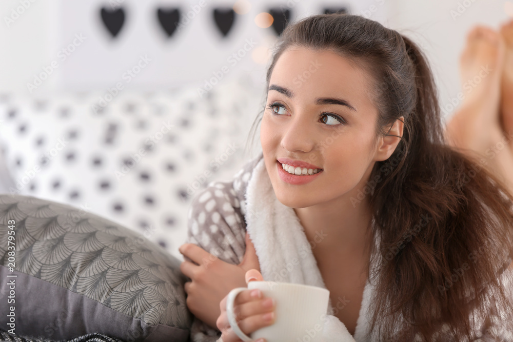 家里有一杯热茶的漂亮年轻女人