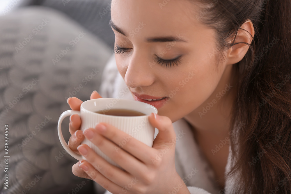 家里有一杯热茶的漂亮年轻女人，特写