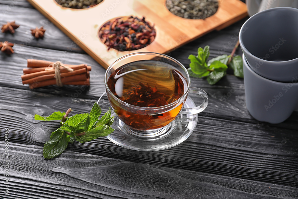 Glass cup with aromatic tea on table