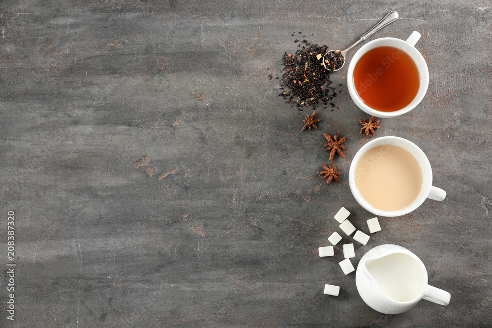 Flat lay composition with tea, milk and sugar on grey background