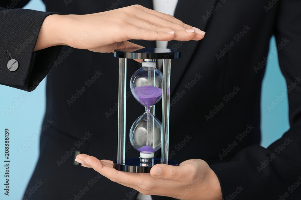 Woman holding hourglass, closeup. Time management concept