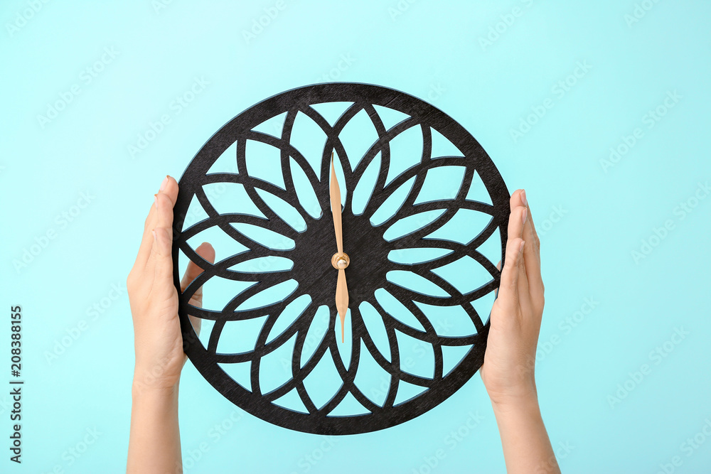 Woman holding clock on color background. Time management concept