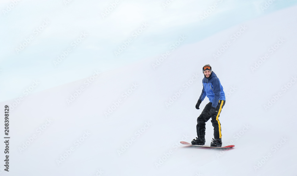 冬季滑雪场斜坡上的男子单板滑雪运动员