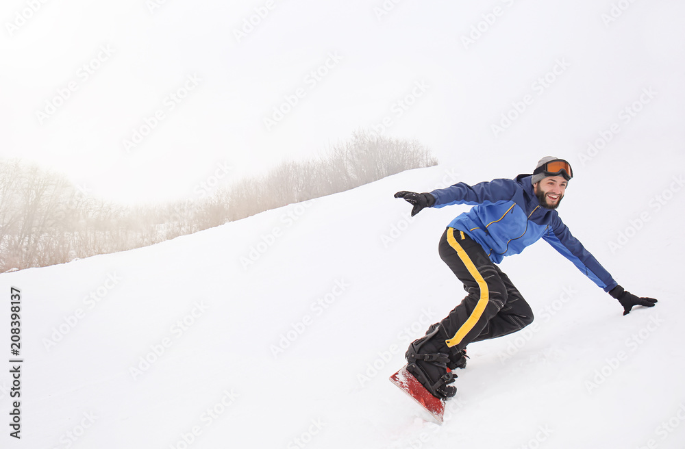 冬季度假胜地斜坡上的男单板滑雪运动员