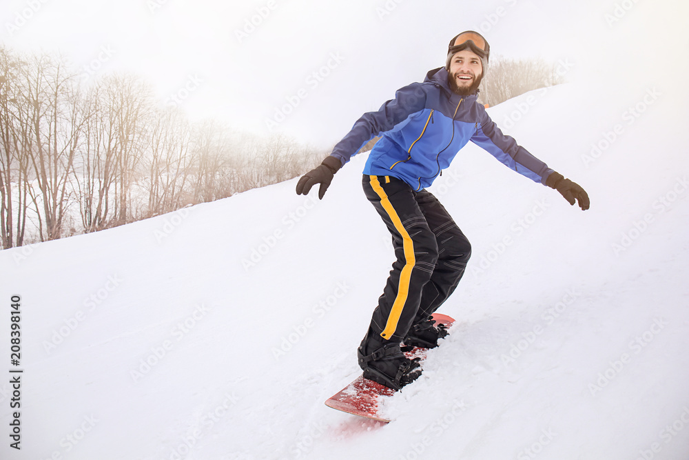 冬季度假胜地斜坡上的男单板滑雪运动员