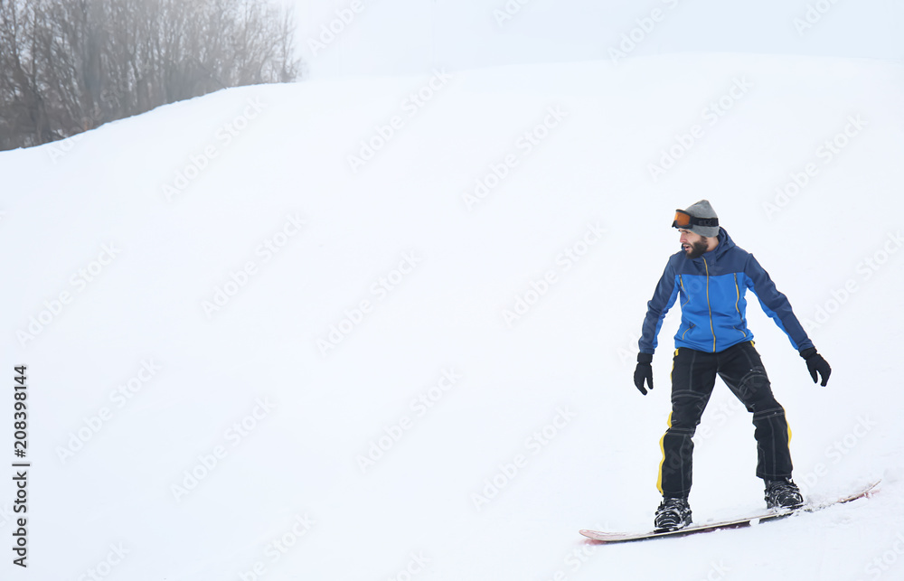 Male snowboarder on slope at winter resort