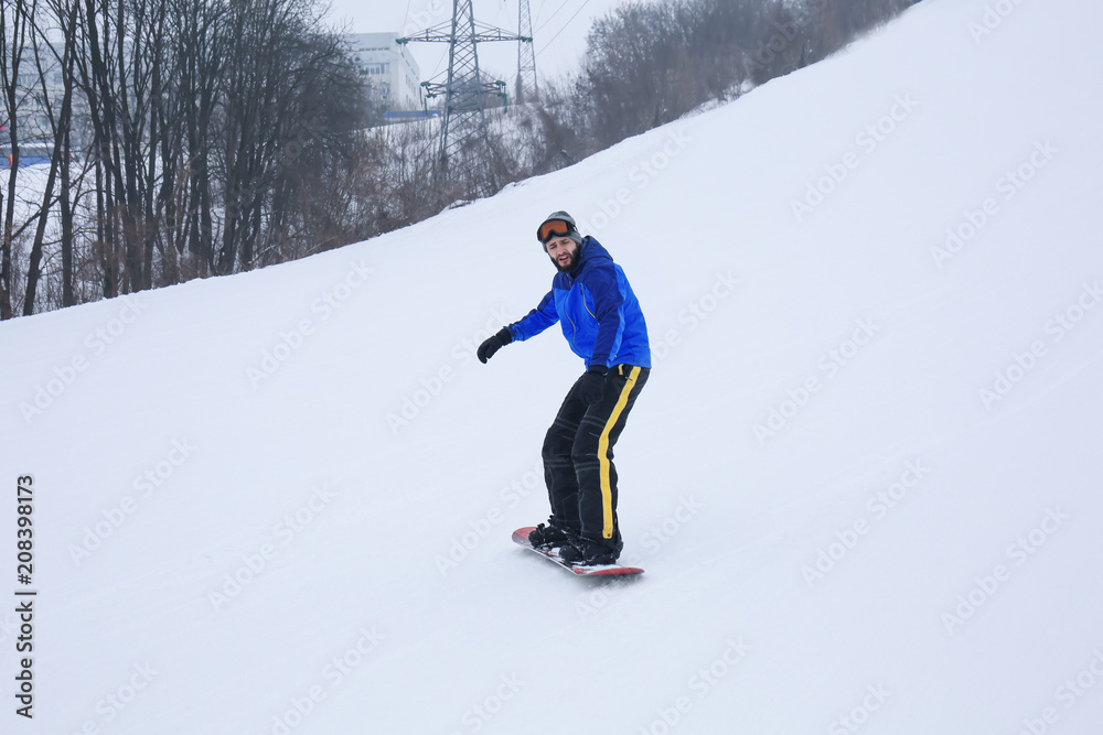 冬季度假胜地斜坡上的男单板滑雪运动员