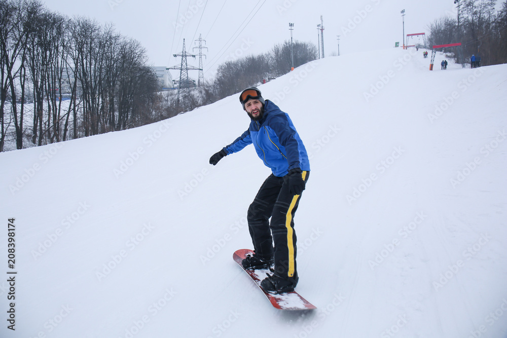 冬季度假胜地斜坡上的男单板滑雪运动员