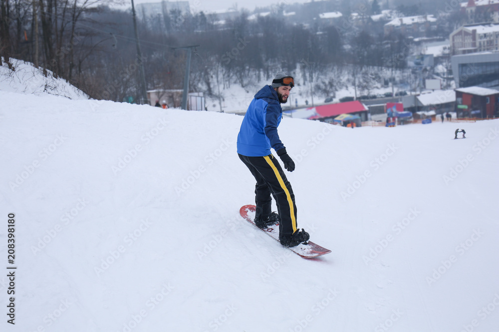 冬季度假胜地斜坡上的男单板滑雪运动员