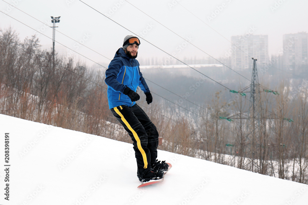 冬季滑雪场斜坡上的男子单板滑雪运动员