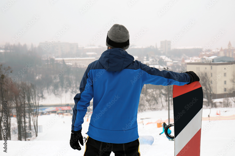 冬季度假胜地斜坡上的男单板滑雪运动员