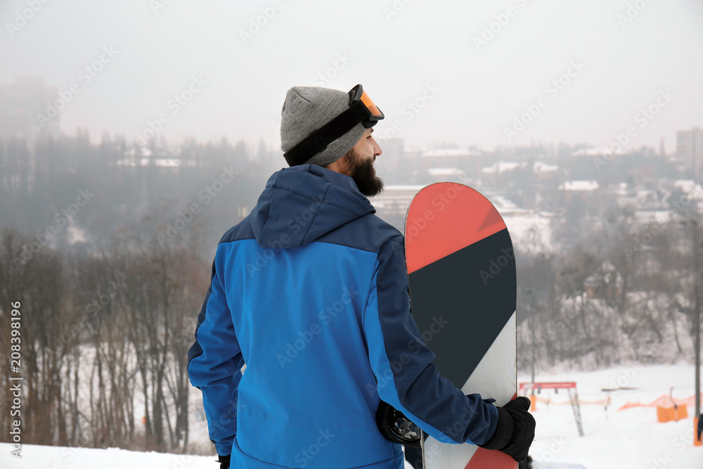 冬季度假区斜坡上的男单板滑雪运动员