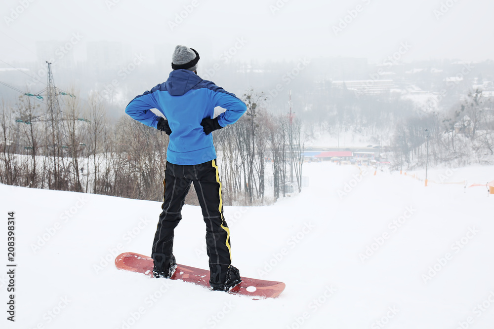 冬季度假胜地斜坡上的男单板滑雪运动员